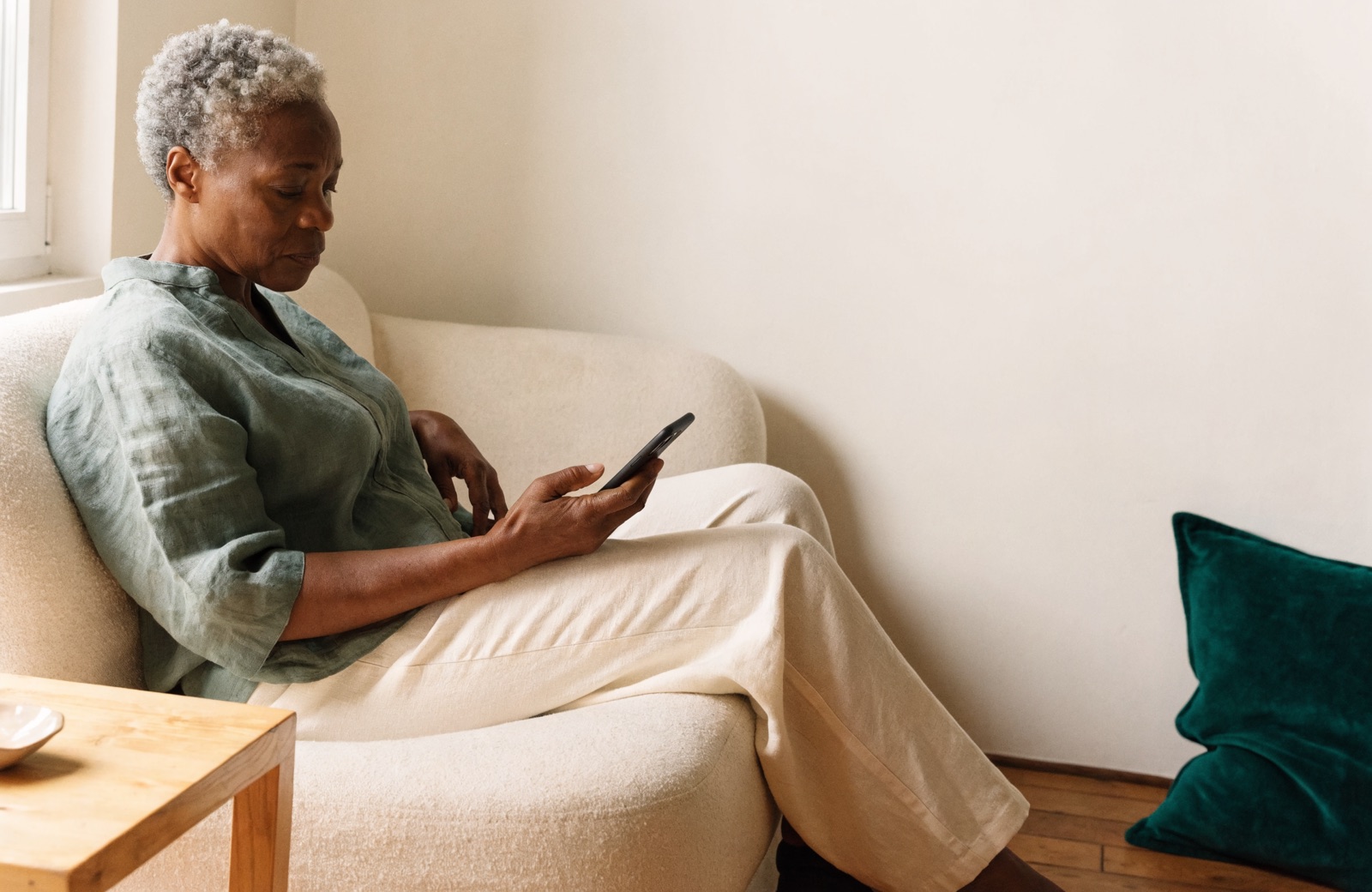 Woman sitting at home looking at her phone.